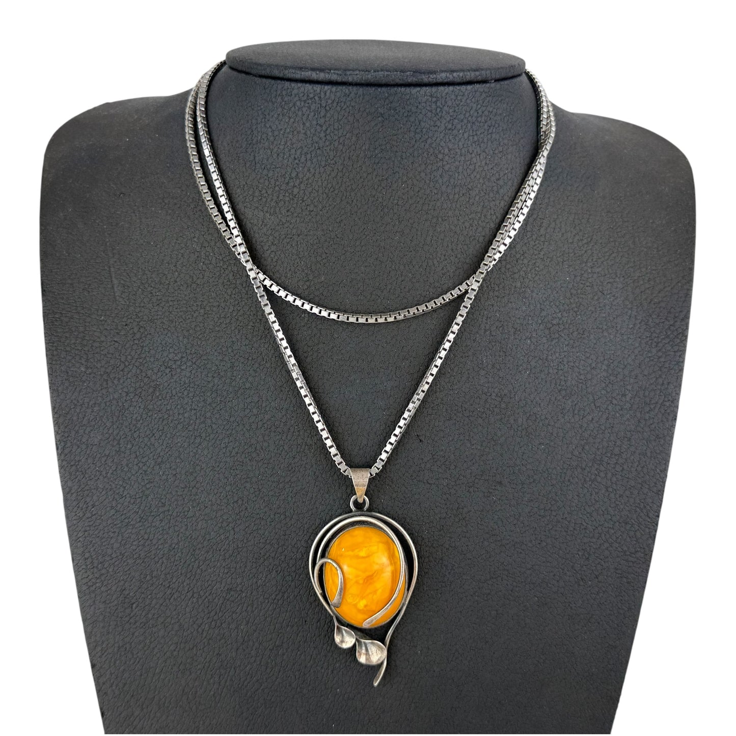 Necklace with a yellow pendant on a gray mannequin bust