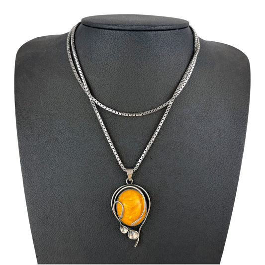Necklace with a yellow pendant on a gray mannequin bust