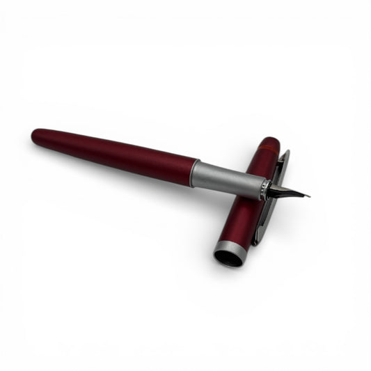 Red rotring pen with silver accents on a white background
