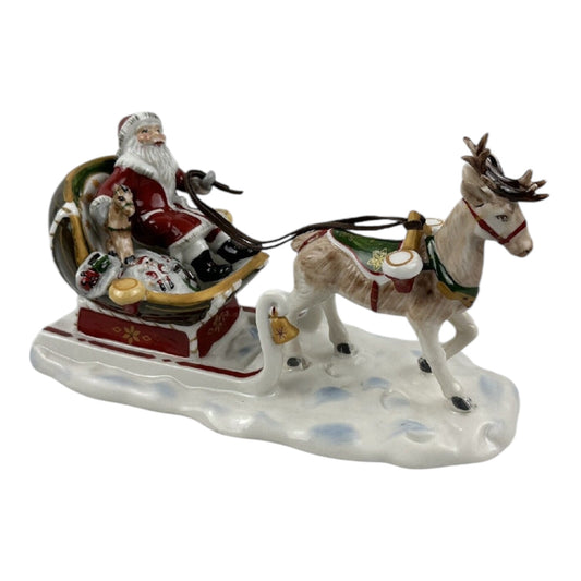 Decorative figurine of Santa Claus in a sleigh pulled by a donkey on a white background