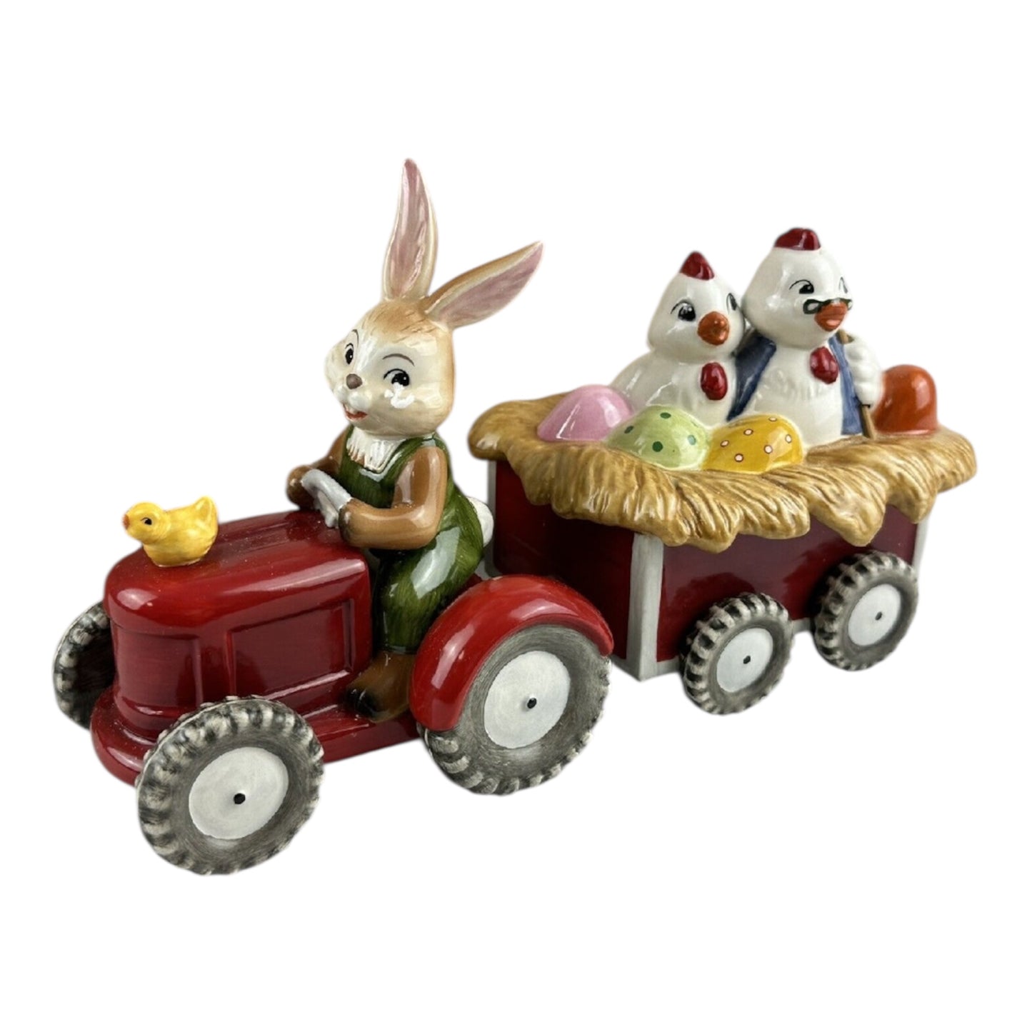 Decorative goebel figurine of a rabbit driving a red tractor with chickens in a cart on a white background