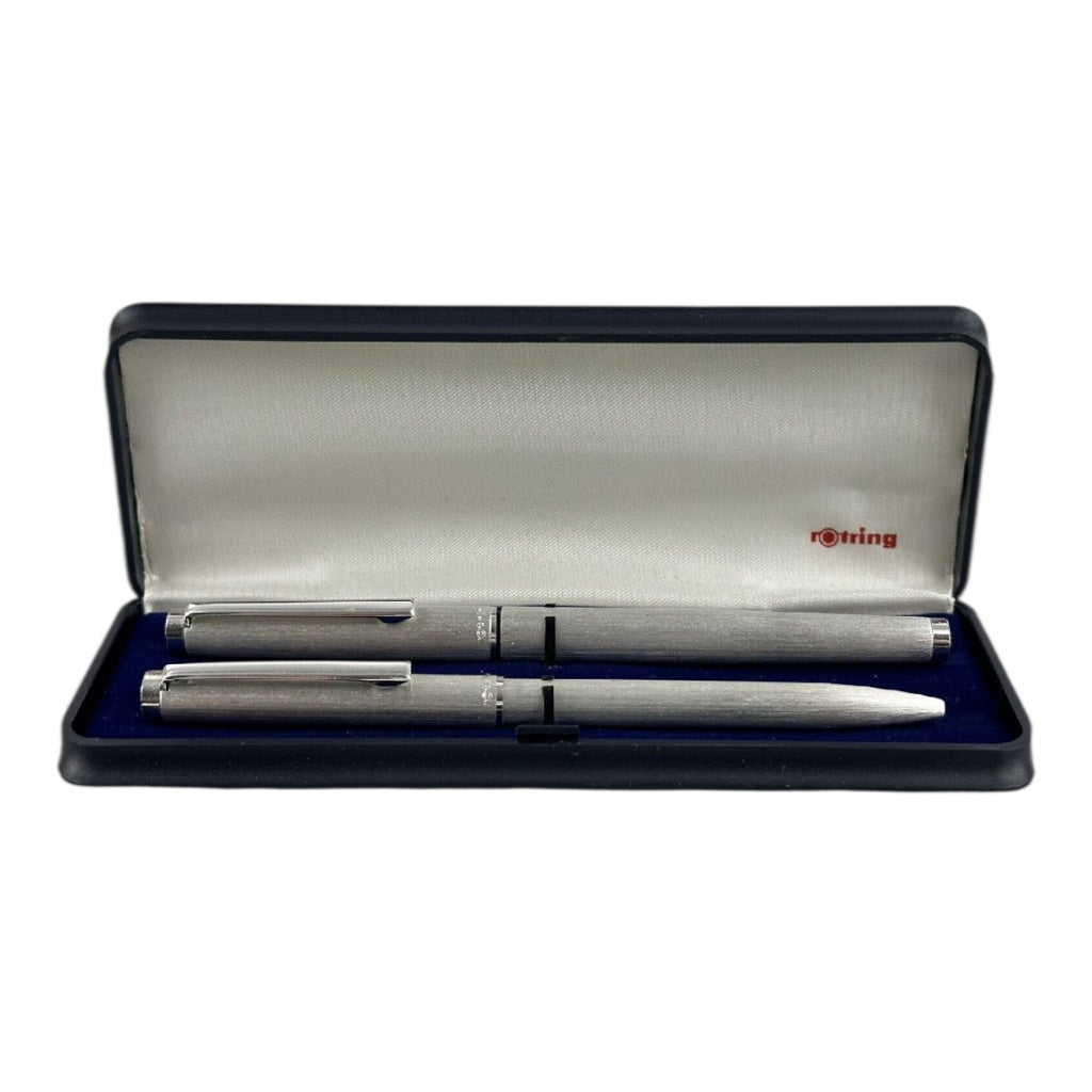 A silver and gold Rotring ballpoint pen set within its original box, which is open displaying the pens and the brand's name on the interior lid.