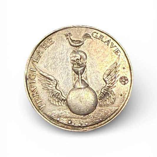 Gold coin with a skull and hourglass design on a white background